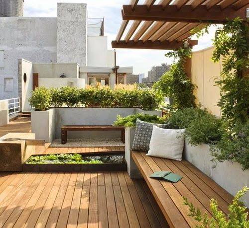 Terrace seating beneath a timber pergola, surrounded by planting.